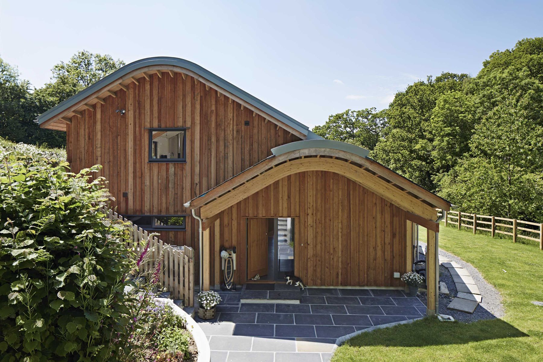 The entrance is sheltered by a wide porch that mimics the shape of the roof