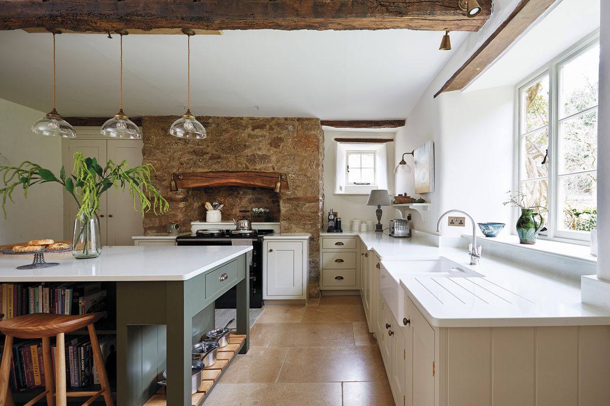 Country kitchen with cream units, green island and white worktops