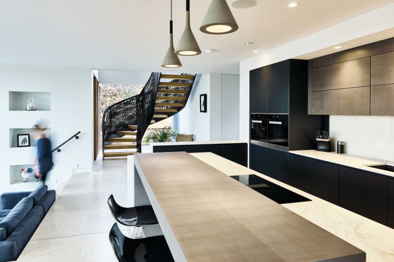 Sleek modern kitchen with view of staircase