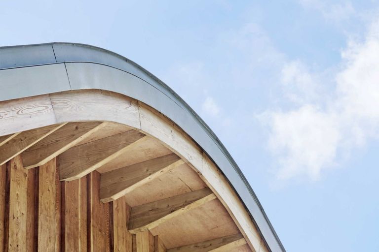 Topped with a curved sedum roof, the home’s appearance changes through the seasons