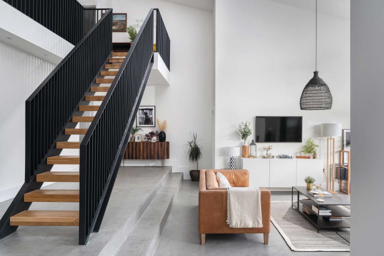 Kohtalo. Striking staircase with wooden treads and black metal handrail
