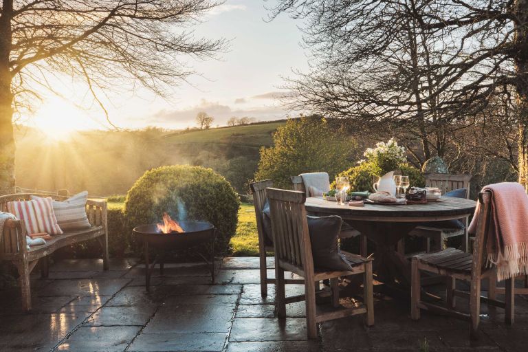 Pastourelle. Garden at sunset with bare winter tress and open fire